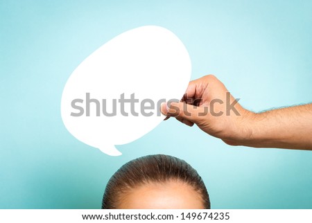 Woman thinking with white comic/speech bubble concept. Hand holding a speech bubble over top of head of woman. No face.