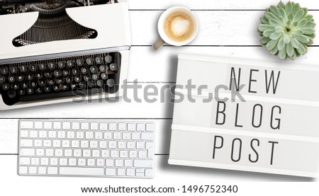 blogging concept, top view of text NEW BLOG POST on light box on table with old typewriter, computer keyboard and cup of coffee Royalty-Free Stock Photo #1496752340