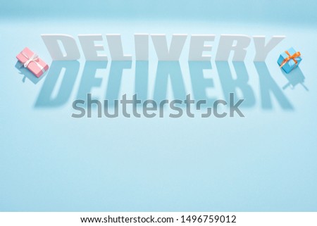 white delivery inscription with shadows near gift boxes on blue background