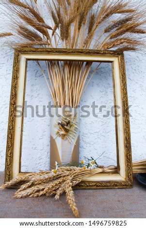 Autumn still life with ears of wheat and rye in a frame from a picture