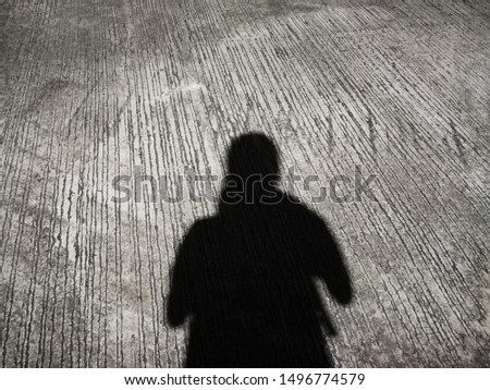 The silhouette of a woman from an electric light bulb on the street