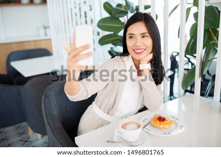 technology and people concept - happy asian woman with cake and coffee taking selfie by smartphone at cafe