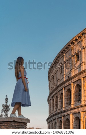 Lonely girl standing and looking over to ancient colosseum, Rome, Italy. 