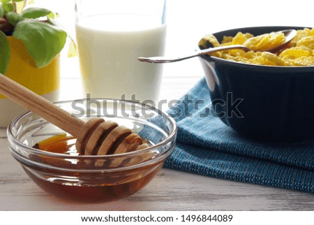 set of honey, cornflakes and milk on a blue napkin, healthy breakfast