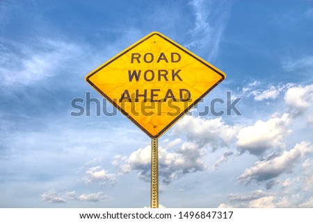 Road work ahead sign with clouds Royalty-Free Stock Photo #1496847317