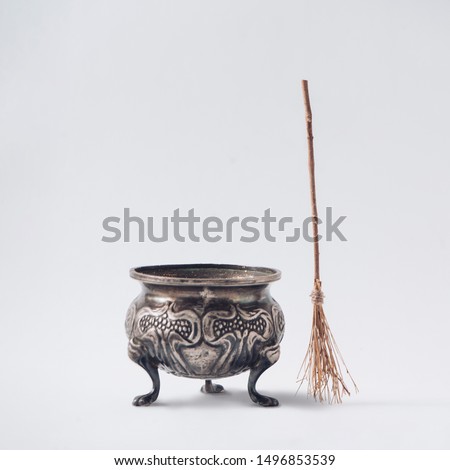 Halloween witch's broomstick with pot or cauldron. Minimal holiday celebration horror concept. Bright autumn season background.