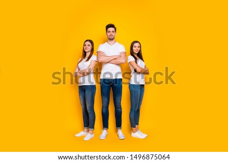 Full body photo of charming people with their arms crossed looking wearing white t-shirt denim jeans isolated over yellow background