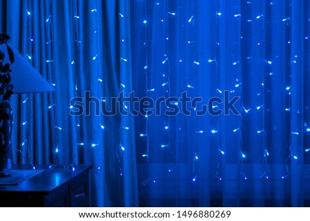 Blurred view of the window, illuminated with a garland as a background	
