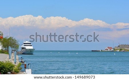 Niagara river panorama landscape, with view of a boat anchored at the Niagara-on-the-Lake harbor and Fort Niagara, NY state in the background