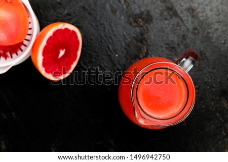 Some freshly squeezed Grapefruit Juice on a vintage background (close-up shot; selective focus)