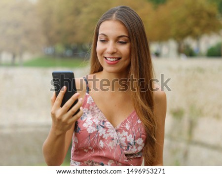 Young fashion woman doing video call outdoor.