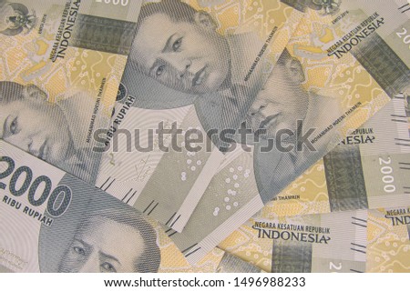 Close up top view of People woman man hand over stack packs bundle pile new uang idr 2000 2.000 rupiah Indonesia money. Give take shake, activity buy sell, pay bill, gift bribe,lebaran THR amplop vast
