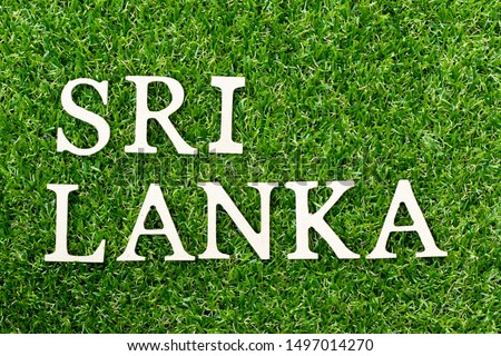 Wood alphabet letter in word Sri Lanka on green grass background