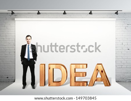 young businessman standing on studio and wooden text idea
