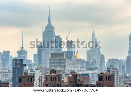 View of New York City from Brooklyn Bridge in the morning with cloudy day.