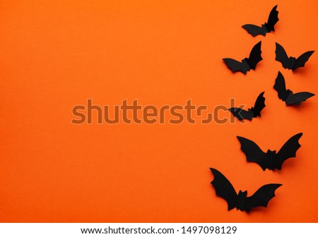 halloween  concept - black paper bats flying over orange background