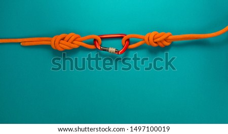 Red carbine with clutch. Equipment for climbing and mountaineering. Safety rope. Knot eight. Royalty-Free Stock Photo #1497100019
