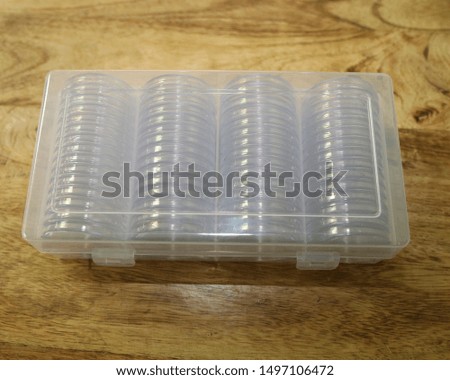 A plastic container with individual acrylic coin holders capsules inside for coin collection protection. Protects coins from scratching.