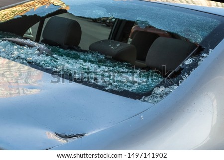 Broken rear glass of car, spread fragments of glass on asphalt