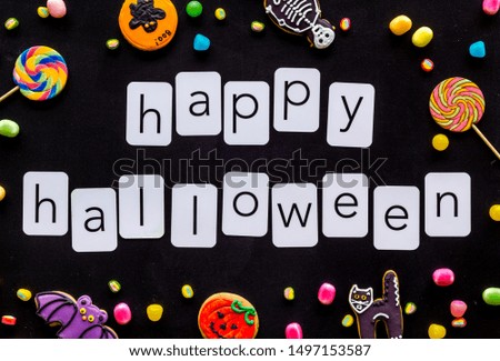 Halloween cookies frame in shape of spooky figures with happy halloween copy on black background top view
