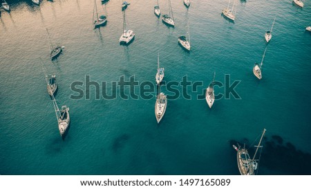 Aerial shot of docked sailing boats in the turquoise waters of Paxos island, Greece