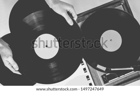 Retro style, woman hands holding vinyl record, vinyl player with records on white background, 80s, top view