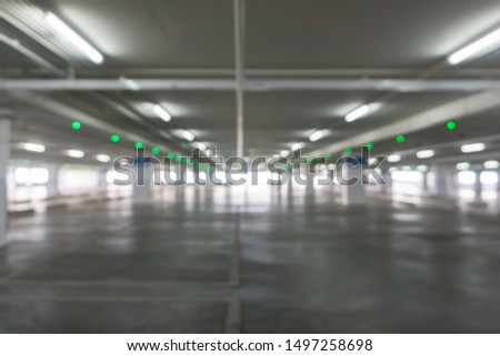 Defocused blur image of empty parking garage interior at shopping mall , Industrial building for background.