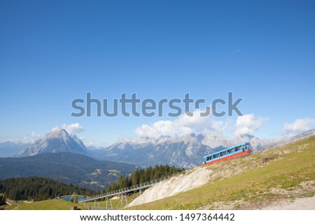 A picture of a Seefeld train transporting tourists down the hill in Seefeld area, Austria.