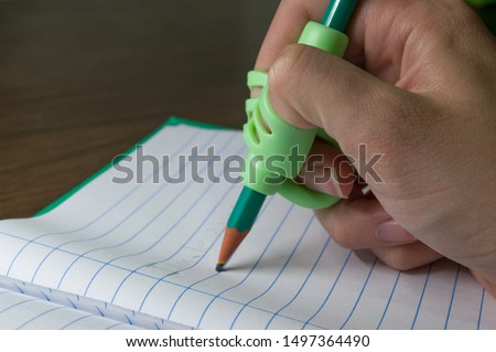 hand using Anti-Shortsighted Pencil Holder made with Silicone for Childrens to correct the writing posture
