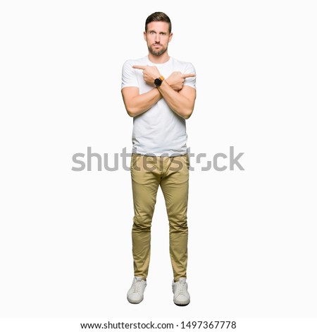 Handsome man wearing casual white t-shirt Pointing to both sides with fingers, different direction disagree