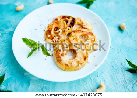 Grilled apples with cinamon on white plate on blue background. Grilled dessert. Barbecue fruit. Copy space. Healthy food. Vegan food.