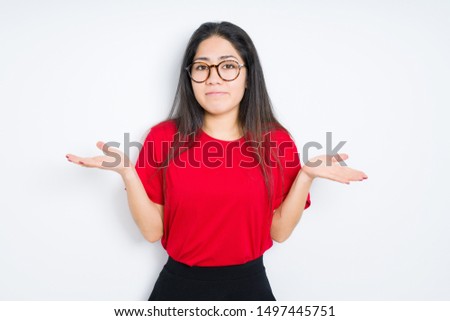 Beautiful brunette woman wearing glasses over isolated background clueless and confused expression with arms and hands raised. Doubt concept.