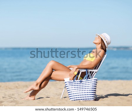 summer holidays and vacation - girl in bikini sunbathing on the beach chair