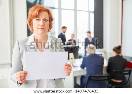 Senior businesswoman holds blank sign in office
