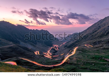 Long exposure with National Road 7C (DN7C), nicknamed Transfagarasan from the Fagaras mountains. The lights of the nostrils draw the path of the road. Photo taken on August 30th, 2019. Royalty-Free Stock Photo #1497499598