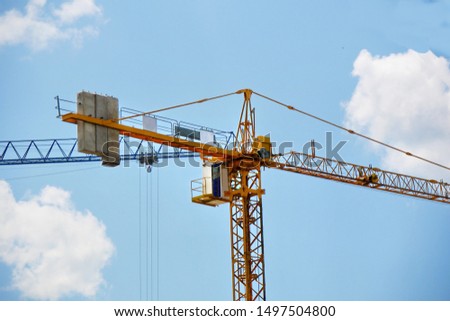 Construction crane near the building under construction. Self-erection crane. Industrial background.