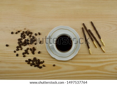Hot Coffee cup and coffee beans roating on the wooden table and the coffee on the table and chocolate top view