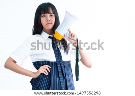 Asian pretty teen girl holding Megaphone in hand and looking at camera, on white background