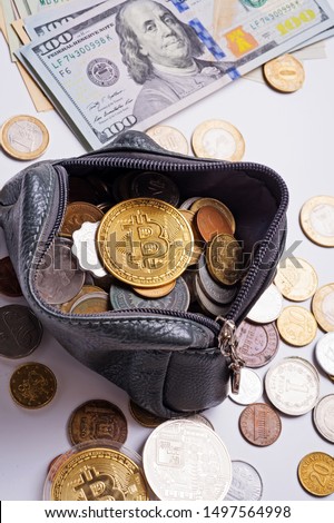 golden bitcoin over  money coins  in wallet around international currency coins and dollars