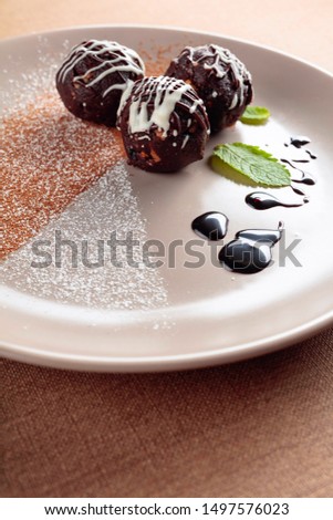 Chocolate balls with mint on a beige plate. Selective focus.