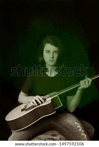 Portrait of a teenager playing guitar in studio