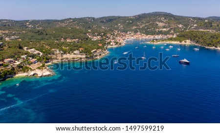 Aerial shot of Gaios port with many anchored sailing boats in the open sea, Paxos island