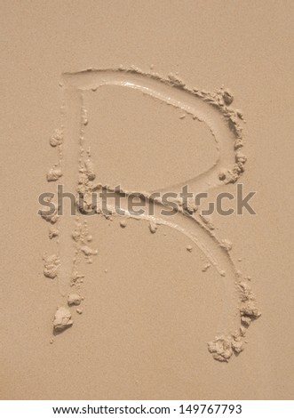 The alphabet written in sand on a beach - R