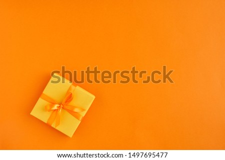 Gift box with ribbon and bow on color background and space for text. Top view	                