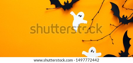 Happy Halloween holiday concept. Orange Halloween background design of Halloween decorations, bats, ghosts. Horizontal Halloween poster, greeting card mockup, website hero header template.