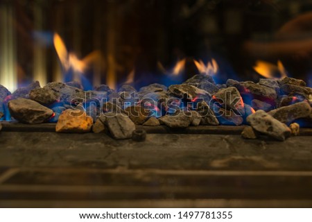 A glowing fire in the stone fireplace to warm a chilly night at the peak of Queenstown skyline gondola in the south island of new zealand. Image captured by a backpacker waiting for the dinner buffet.