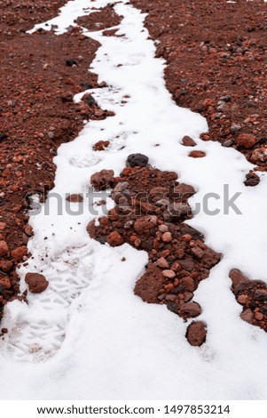Footprints on the snow while climbing the rocky slopes of the Chimborazo volcano in Ecuador