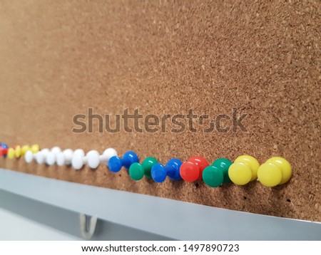 Colorful push pins on the cork board. Stationery and office concept. There is copy space for adding text.