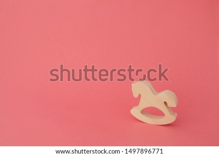 Toy horse made of wood on pink background