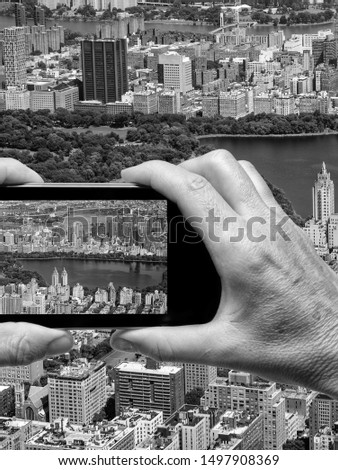 Man and woman hand capturing New York aerial skyline with smartphone